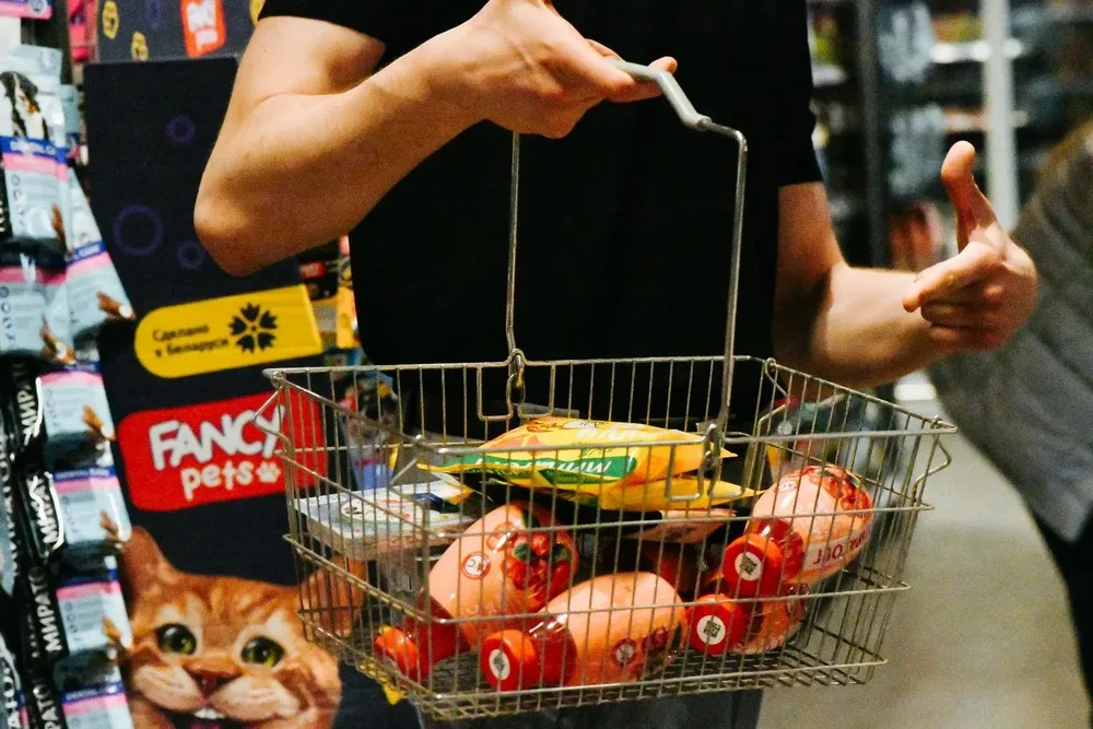 Покупатель с корзиной продуктов в супермаркете