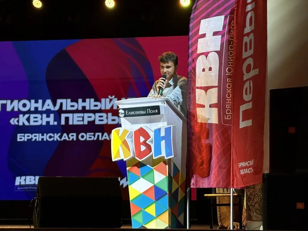 Ведущий Кубка КВН на сцене с микрофоном