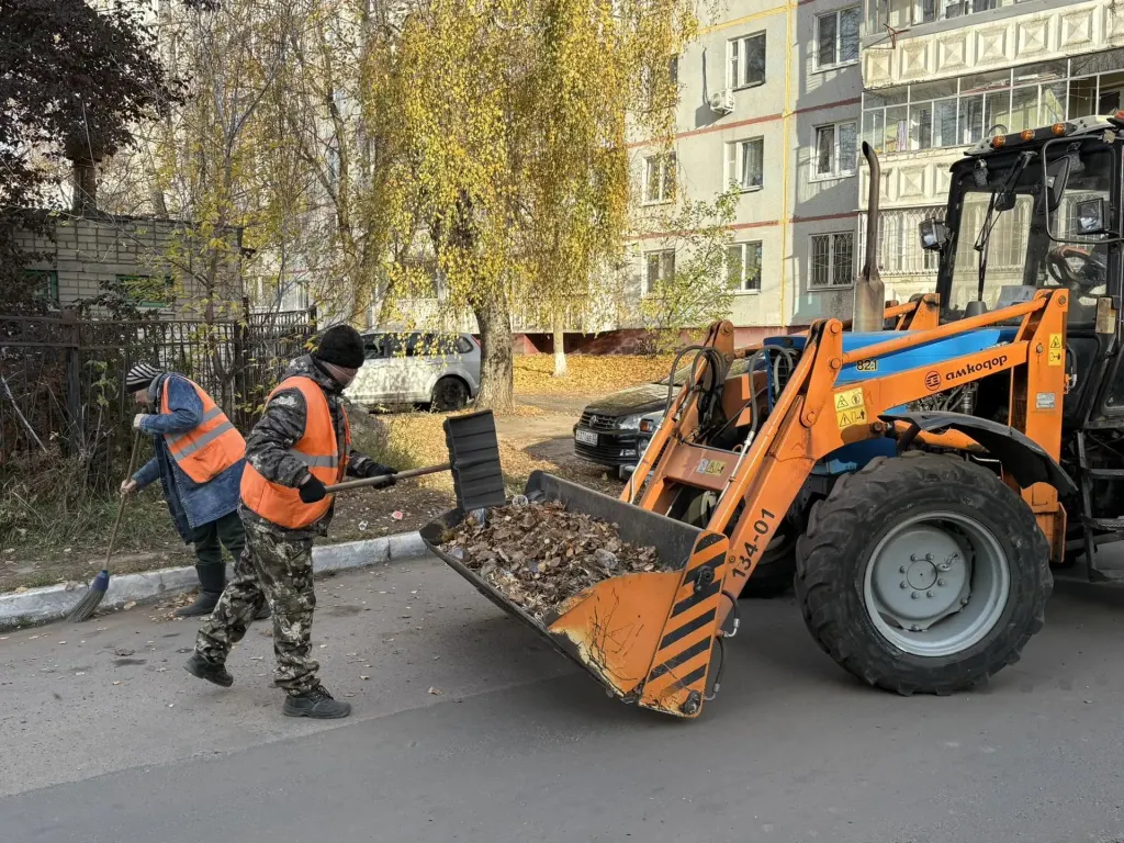 Рабочие убирают листву специальной техникой