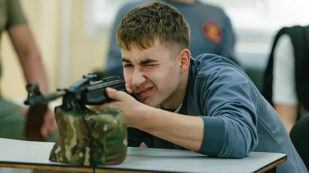 Кадет прицеливается из пневматического оружия