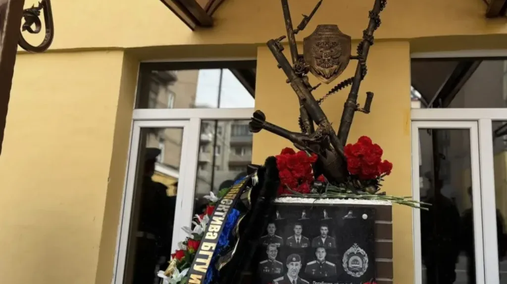 Памятник с портретами павших и красными цветами