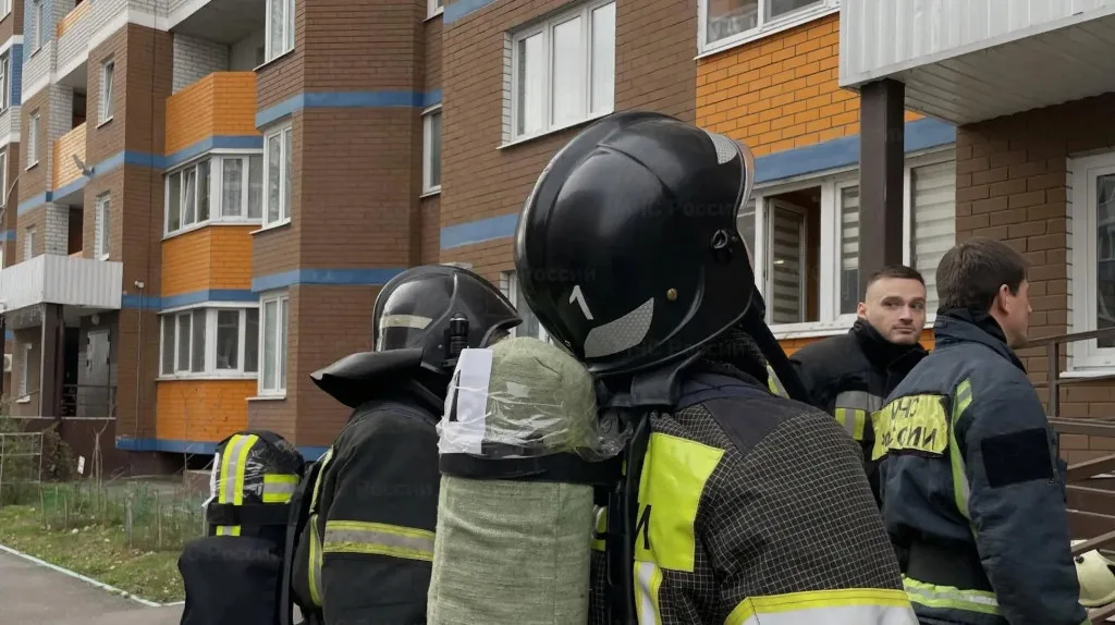 Пожарные в боевой экипировке у жилого дома