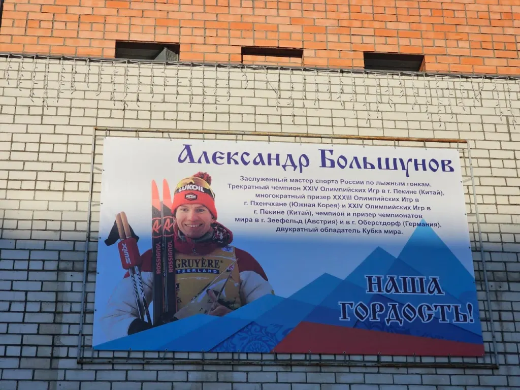Баннер с портретом лыжника Большунова на стене