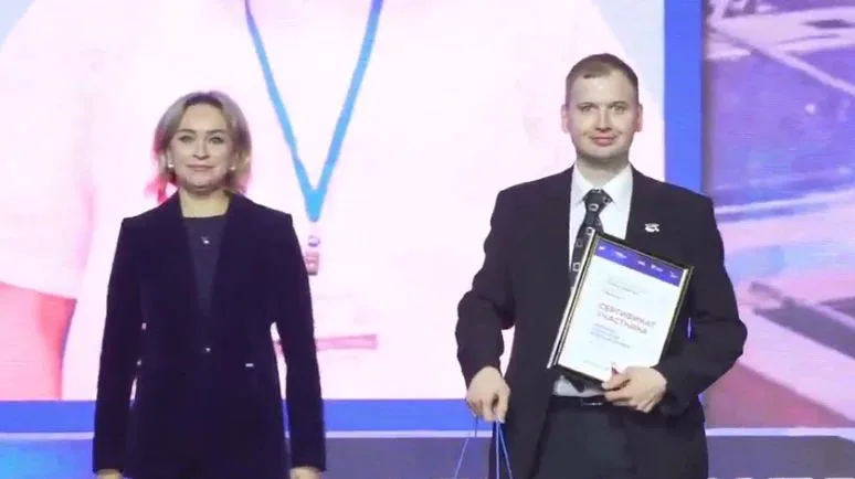 Ветеран получает сертификат на сцене конкурса